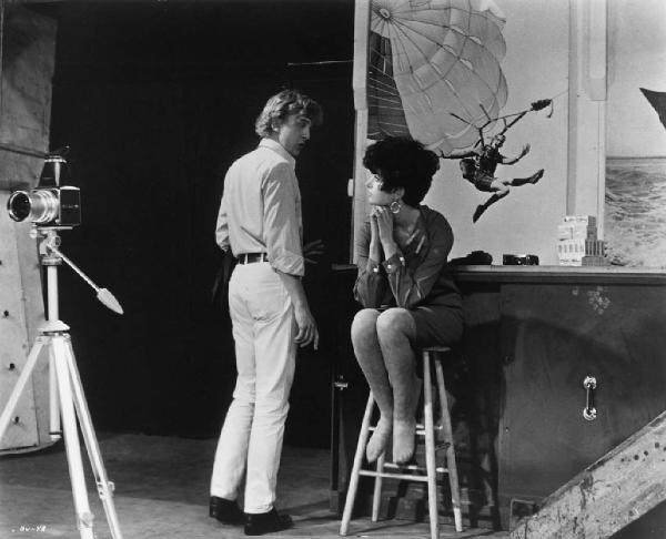 Ritratto. Foto di scena del film Blow-Up. David Hammings e una donna in uno studio fotografico. Macchina fotografica