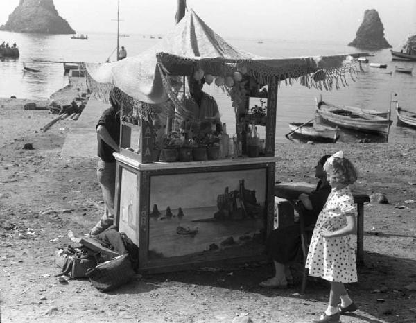 Italia del Sud. Aci Trezza (Catania) - Mare - Chiosco sulla spiaggia - Ritratto infantile: bambina con abito a pois