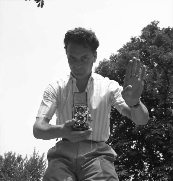 Ritratto maschile - Federico Patellani - regge una macchina fotografica Rolleiflex