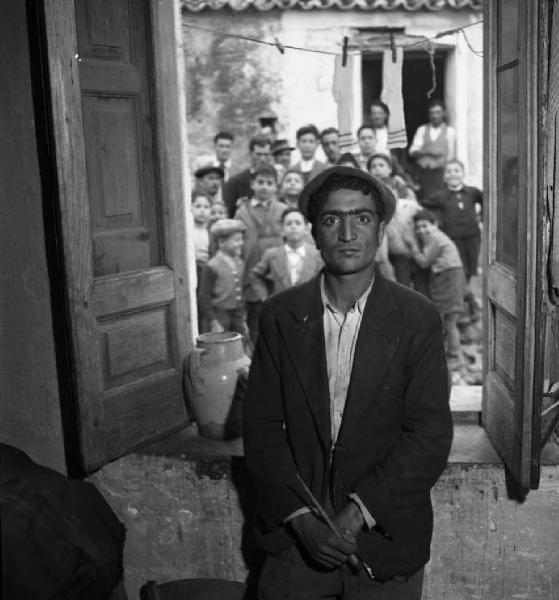 Italia del Sud. Calabria - Interno - Ritratto maschile: uomo appoggiato ad una finestra aperta - Ritratto di gruppo: uomini e bambini all'esterno