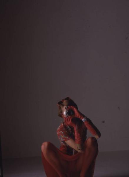 Ritratto femminile - donna in abiti rossi con macchina fotografica