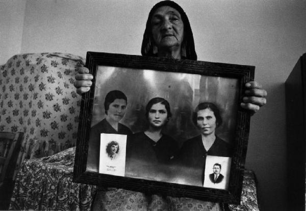 Casa - interno - ritratto femminile - anziana regge una foto di famiglia