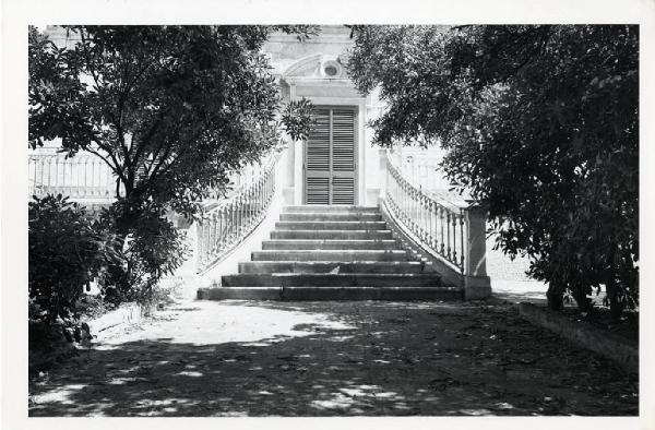 Cozze. Giardino - porta con scalinata e timpano - alberi