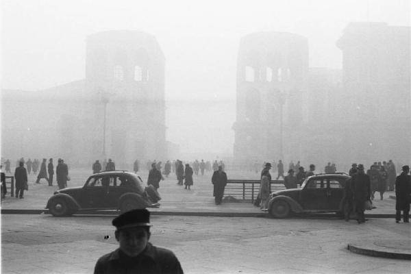 Italia Dopoguerra. Milano - galleria Vittorio Emanuele - Scorcio di piazza del Duomo con un giovane passante in primo piano