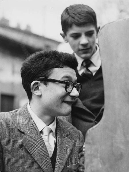 Luna park. Milano - Luna park - Ritratto maschile - Ragazzo con occhiali davanti a un gioco, ragazzo in secondo piano