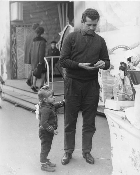 Luna park. Milano - Luna park - Banchetto zucchero filato - Ritratto di famiglia - Uomo con bambina con treccia - Giostre sullo sfondo