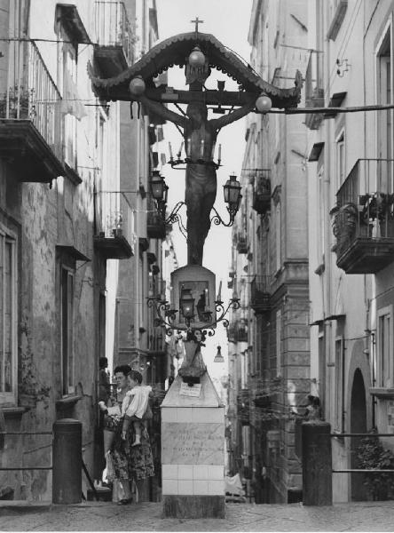 Napoli: La fede. Napoli - Vicoli - Edicola votiva: crocifisso ligneo con candele e luci - Donna con bambino - Religione