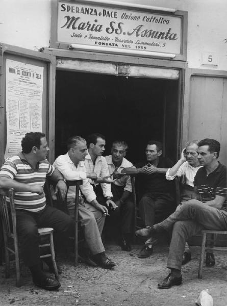 Napoli: La fede. Napoli - Vicoli - Traversa Lammatari, 5 - Ritratto di gruppo - Uomini seduti davanti alla sede dell'Unione Cattolica