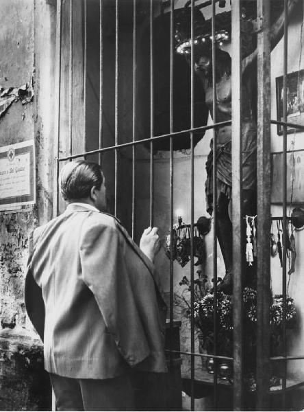 Napoli: La fede. Napoli - Ritratto maschile - Anziano davanti a edicola votiva con il crocifisso ligneo - Religione