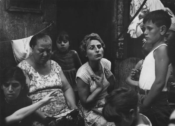 Napoli: Conversazioni. Napoli - Vicoli - Ritratto di gruppo - Donna con le mani al petto circondata da altre donne e bambini - Gioco della tombola