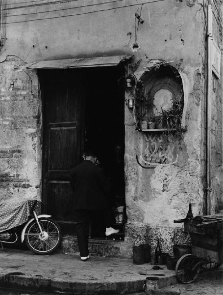 Napoli: Altarini. Napoli - Strada - Uscio di una casa - Edicola votiva - Anziani sulla porta - Motocicletta - Religione