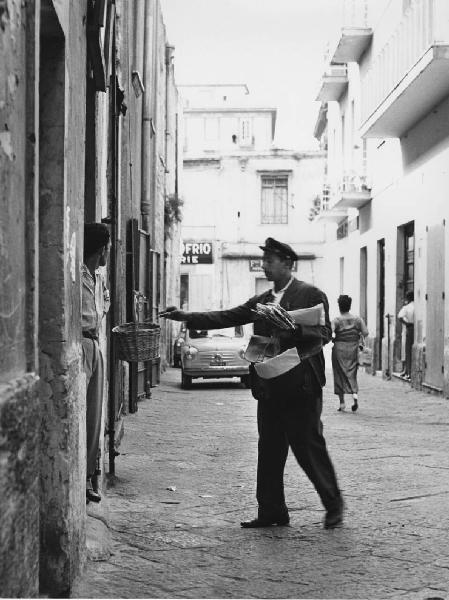 Napoli: Scene di vita varie. Napoli - Vicoli - Ritratto maschile - Uomo postino consegna la posta in un cestino di vimini con carrucola