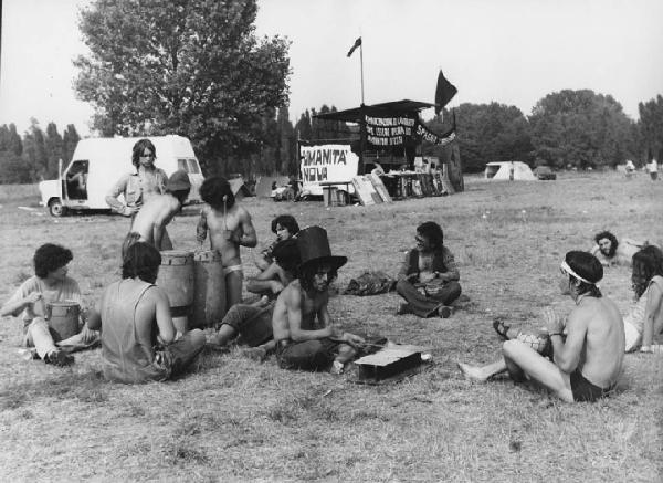 Festival Pop. Zerbo - Festival pop di Re nudo - Ragazzi seduti nel prato con tamburi - Palco sullo sfondo