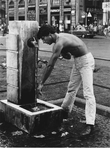 Mondo Beat. Milano - Piazza del Duomo - Ritratto maschile - Ragazzo a torso nudo si lava alla fontanella