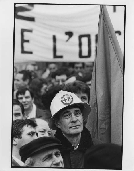Manifestazione Alfa Romeo. Milano - Manifestazione operaia Alfa Romeo - Gruppo di operai, operaio con cappello con simbolo Alfa Romeo