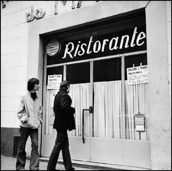 Milano - Piazza Beccaria 12 - Ristorante, esterno: porta a vetri con tendine - Due uomini davanti l'entrata - Insegna al neon - Cartelli