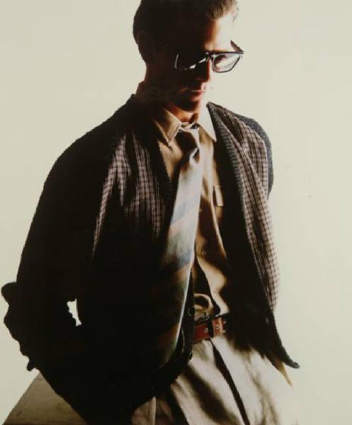 Campagna pubblicitaria per Trussardi Uomo - Modello con maglione scozzese, pantaloni di tela beige, camicia, cravatta regimental e occhiali