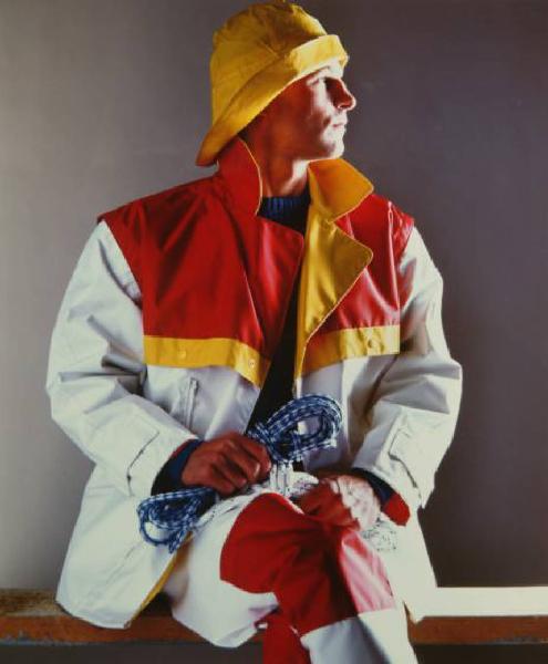 Campagna pubblicitaria per Trussardi Uomo - Sportswear - Modello seduto di profilo: cerata colorata, cappello, stivali e due scotte - Marinaio