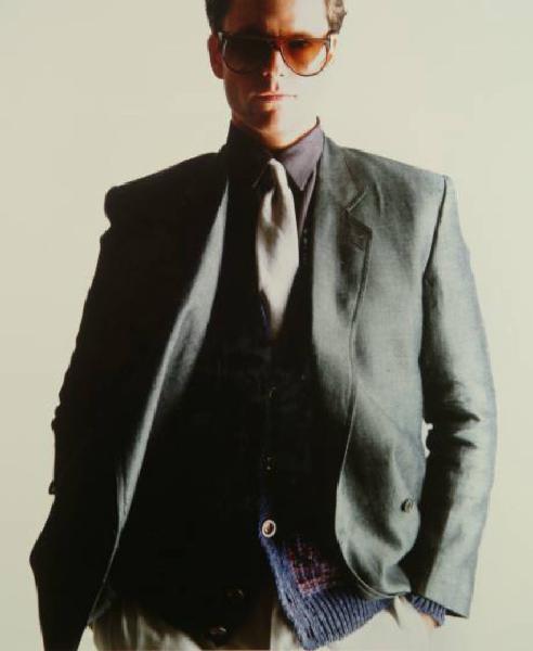 Campagna pubblicitaria per Trussardi Uomo - Modello con giacca grigia su maglione in fantasia, camicia, cravatta e occhiali da sole