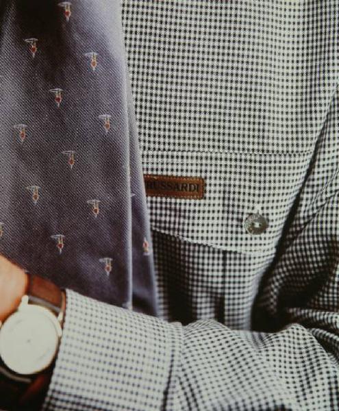 Campagna pubblicitaria per Trussardi Uomo - Dettaglio: modello con giacca pied-de-poule, cravatta con i levrieri e orologio - Logo Trussardi