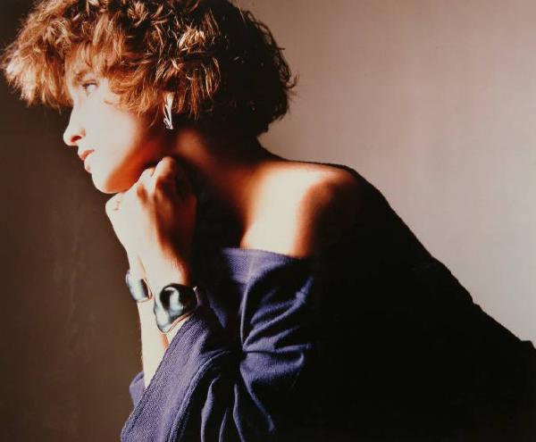 Campagna pubblicitaria per Trussardi Donna - Modella di profilo: abito viola scivolato sulle spalle, bracciali e orecchini metallici