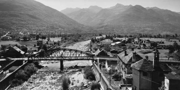 Fondovalle - fiume fiancheggiato da un centro abitato e attraversato da un ponte