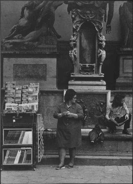 Firenze: Loggia della Signoria - Ritratto femminile a figura intera: Anna V., venditrice di souvenirs - Bancarella con cartoline e libri - Ragazzo seduto sui gradini