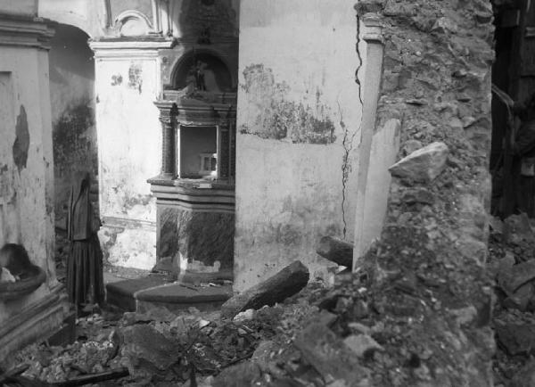 Italia del Sud. Calabria - terremoto - donna prega tra le macerie della chiesa