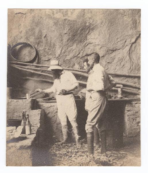 Ritratto maschile - Filippo Camperio cucina nella grotta di Shan Khai Kwan osservato da due uomini - Cina - Shan Khai Kwan