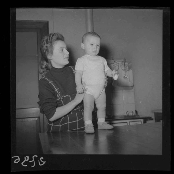 Ritratto infantile - Famiglia Gadioli - Bambino in piedi sul tavolo vicino alla madre - Interno