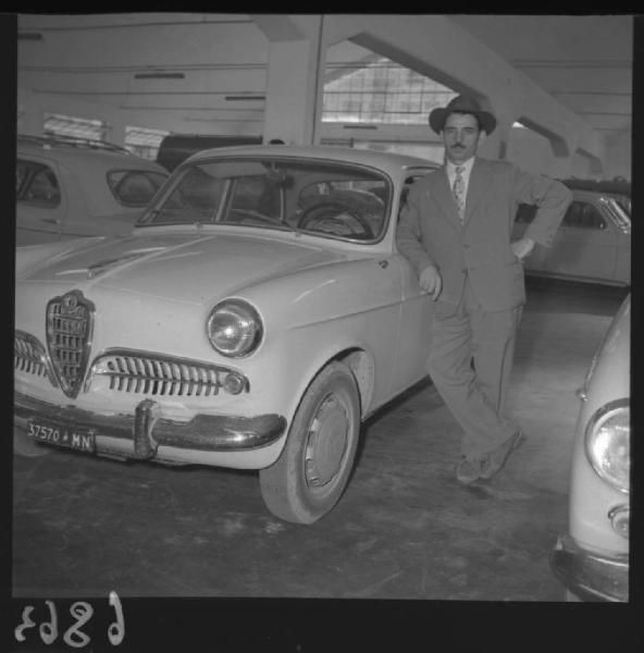 Ritratto maschile - Uomo appoggiato ad un'autovettura - Interno di officina