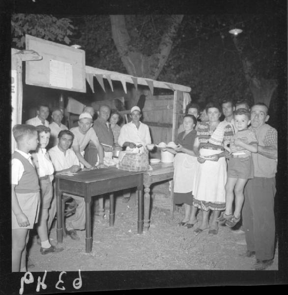 Ritratto di gruppo - Festa dell'Unità - Volontari e volontarie al tavolo d'ingresso della festa con il risotto - Virgilio - Esterno