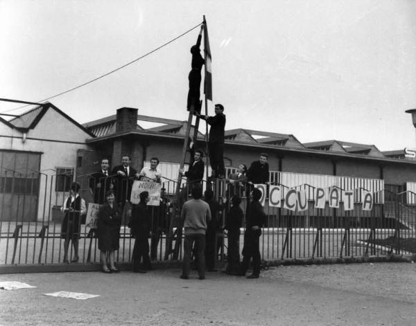 Saini - Occupazione della fabbrica contro i licenziamenti - Lavoratori dietro ai cancelli - Cartelli di fabbrica occupata e di protesta - Bandiera italiana