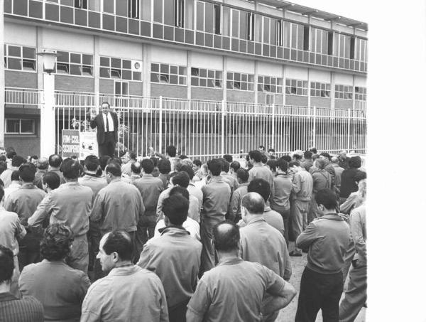 Sciopero dei lavoratori della Triplex - Comizio davanti all'ingresso della fabbrica - Pierluigi Perotta al microfono - Cartello di sciopero Fim Cisl - Operai con tuta da lavoro