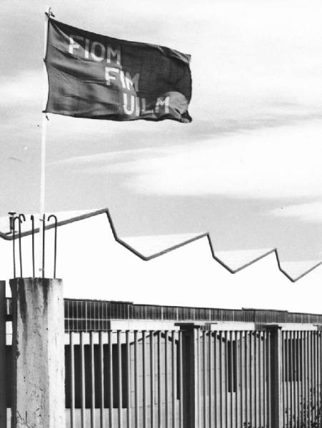 Società Italiana Pompe Aturia - Bandiera Fiom Fim Uilm sul cancello della fabbrica
