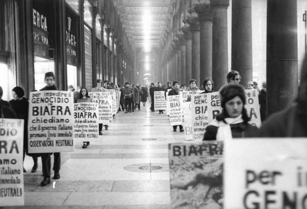 Manifestazione contro la guerra civile in Biafra - Corteo sotto i portici di piazza del Duomo - Cartelli di protesta