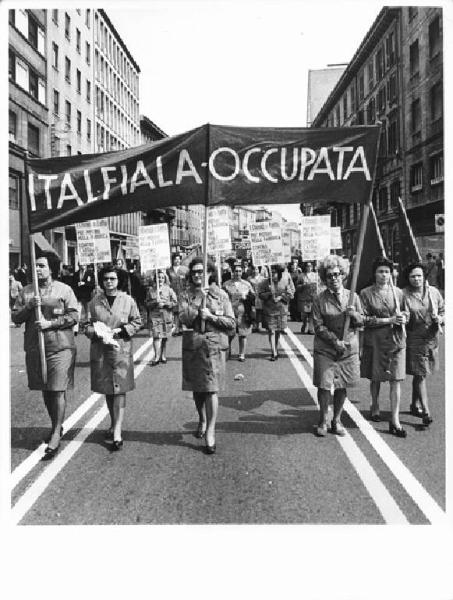 Manifestazione del primo maggio - Corteo in Corso Venezia - Spezzone lavoratrici della fabbrica Italfiala - Operaie con grembiule da lavoro - Striscione - Cartelli - Bandiere