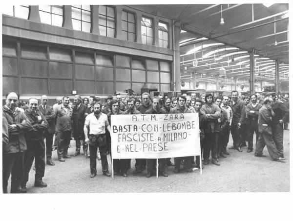 Atm - Deposito Zara - Interno - Assemblea dei lavoratori contro la bomba fascista alla Questura di Milano - Operai con tuta da lavoro - Cartello