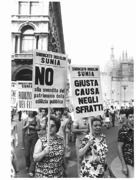 Manifestazione del sindacato inquilini (Sunia) - Corteo in piazza del Duomo - Particolare: donne con cartelli - Il Duomo con impalcature