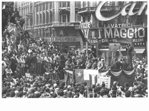 Festa dei lavoratori - Manifestazione del primo maggio - Comizio in piazza del Duomo - Palco - Bruno Storti al microfono - Lavoratori sul monumento a Vittorio Emanuele II - Striscione - Bandiere