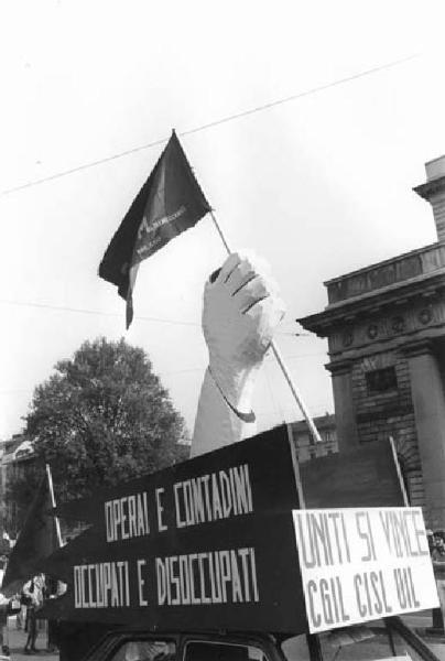 Festa dei lavoratori - Manifestazione del primo maggio - Corteo ai Bastioni di porta Venezia - Auto con scultura in cartapesta - Bandiera Flm