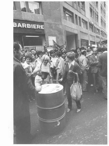 Sciopero dei lavoratori di diverse fabbriche contro i licenziamenti, per l'occupazione - Presidio davanti alla sede dell'Assolombarda - Donne suonano tamburo di latta - Uomo con campanaccio