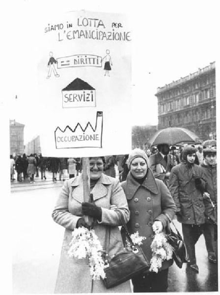 Manifestazione 8 marzo per la giornata internazionale della donna - Corteo - Donne con cartello per l'emancipazione - Mimosa