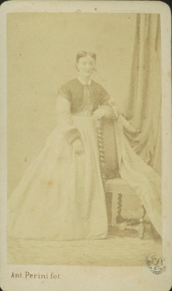 Ritratto femminile - Donna in abito chiaro con corpetto scuro, in piedi accanto ad una sedia dallo schienale alto