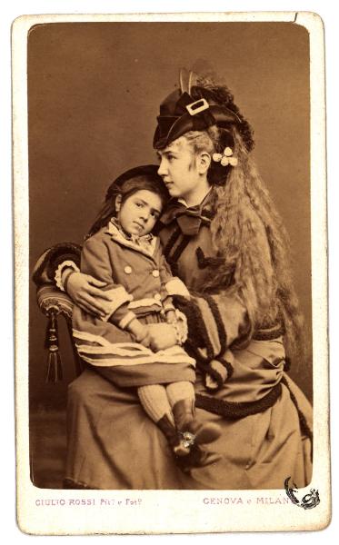 Ritratto di famiglia - Giovane donna con cappello e lunga chioma bionda con una bambina in braccio