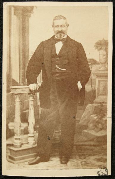 Ritratto maschile - Uomo in piedi accanto a una balaustra e davanti a un fondale dipinto