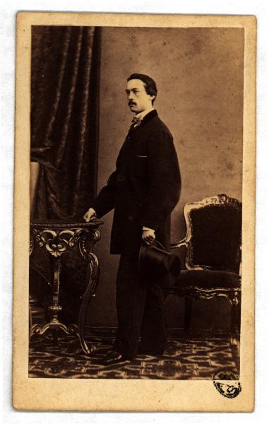Ritratto maschile - Uomo in piedi di profilo con cappello a tuba in mano