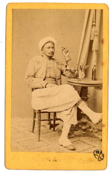 Ritratto maschile - Fuciliere algerino seduto a un tavolo intento a fumare