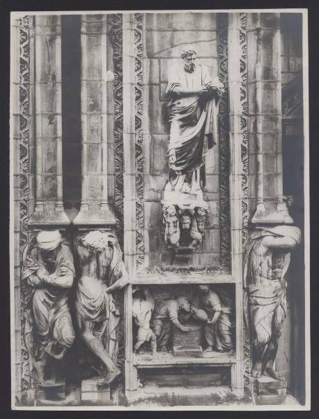 Milano - Duomo. Particolare della decorazione della facciata esterna con altorilievo, cariatidi e statua di S. Marco.