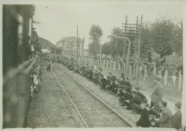 Cerimonia della traslazione della salma del Milite Ignoto - Tratto ferroviario tra Toscana e Lazio - Persone sedute sui binari in attesa del passaggio del treno con la bara del Milite Ignoto